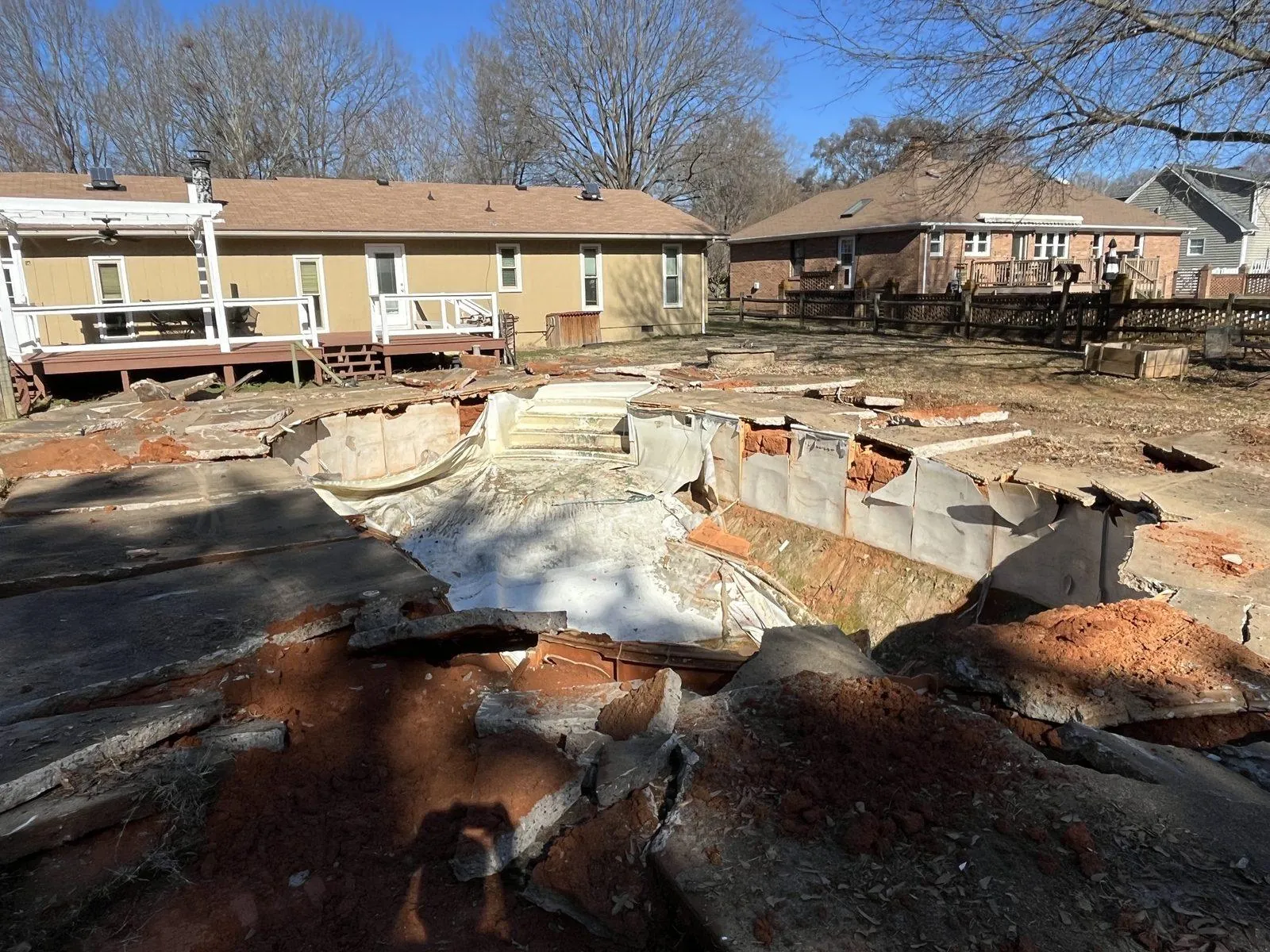 Old in-ground pool with the deck broken up, before the fill-in