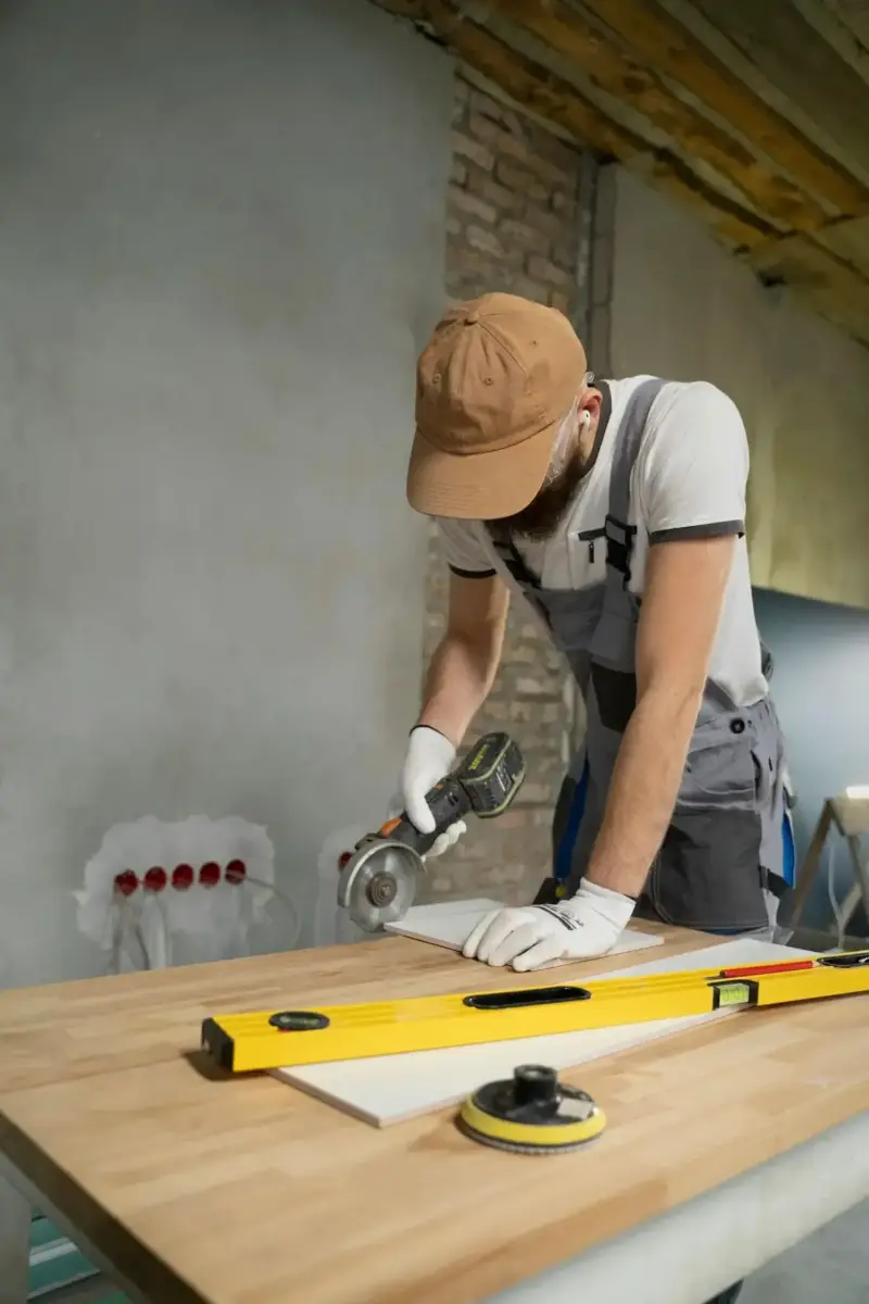 Contractor cutting tile with an angle grinder during a renovation